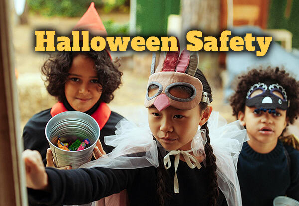 Halloween Safety. Three children dressed up in costumes knocking on a door for candy.